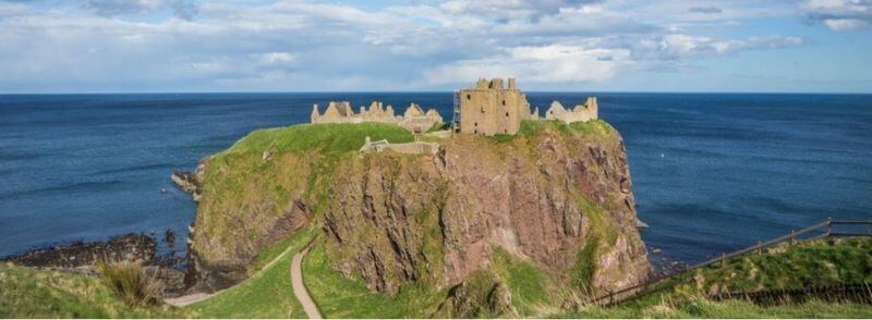 Vista del acceso y el Castillo de Dunnotar en Escocia
