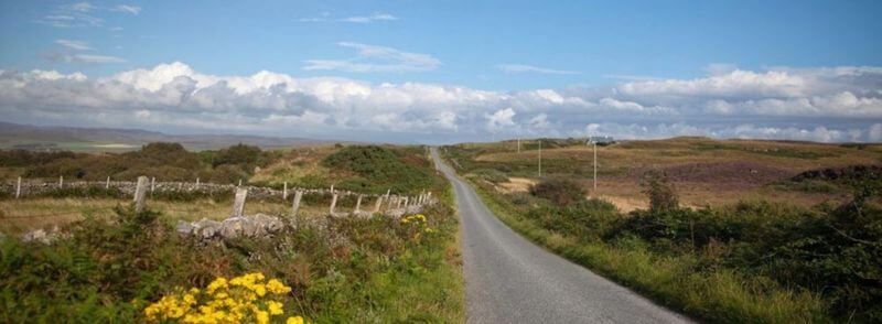 Carretera cruzando el campo de la Isla de Islay en Escocia, Reino Unido